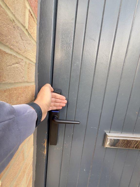 To light up the numbers, simply touch the back of your hand to the smart lock's number pad, as shown in the photo.